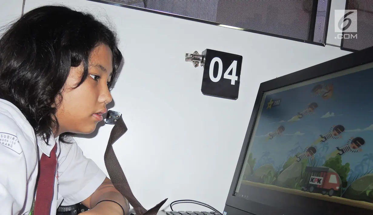 Seorang siswi SD bermain game antikorupsi saat menaiki Bus KPK di Balai Kota Semarang, Jawa Tengah, Sabtu (13/10). Selain melalui game, KPK juga menanamkan antikorupsi melalui dongeng dan film. (Liputan6.com/Gholib)
