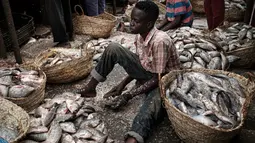 Pedagang ikan membuang sisik-sisik ikan di sebuah pasar ikan di dekat Sungai Nil, di kota kembar Khartoum, Omdurman (24/6/2019). Khartoum memiliki iklim tandus yang panas, hanya pada bulan Juli dan Agustus memiliki presipitasi yang signifikan. (AFP Photo/Yasuyoshi Chiba)