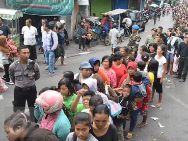 Warga mengantre untuk mendapatkan daging kurban  di jalan Kauman Semarang,Jawa Tengah, Senin (12/9). Panitia kurban membagikan lebih dari 5.000 paket daging kepada warga. (Liputan6.com/Gholib)