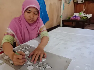 Pengrajin melukis motif sasirangan yang diinginkan di atas kain ukuran 2 meter menggunakan kain katun dan sutera di daerah Sasiranga, Banjarmasin, Kalimantan Selatan (16/1/2017). (Liputan6.com/Novi Nadya)