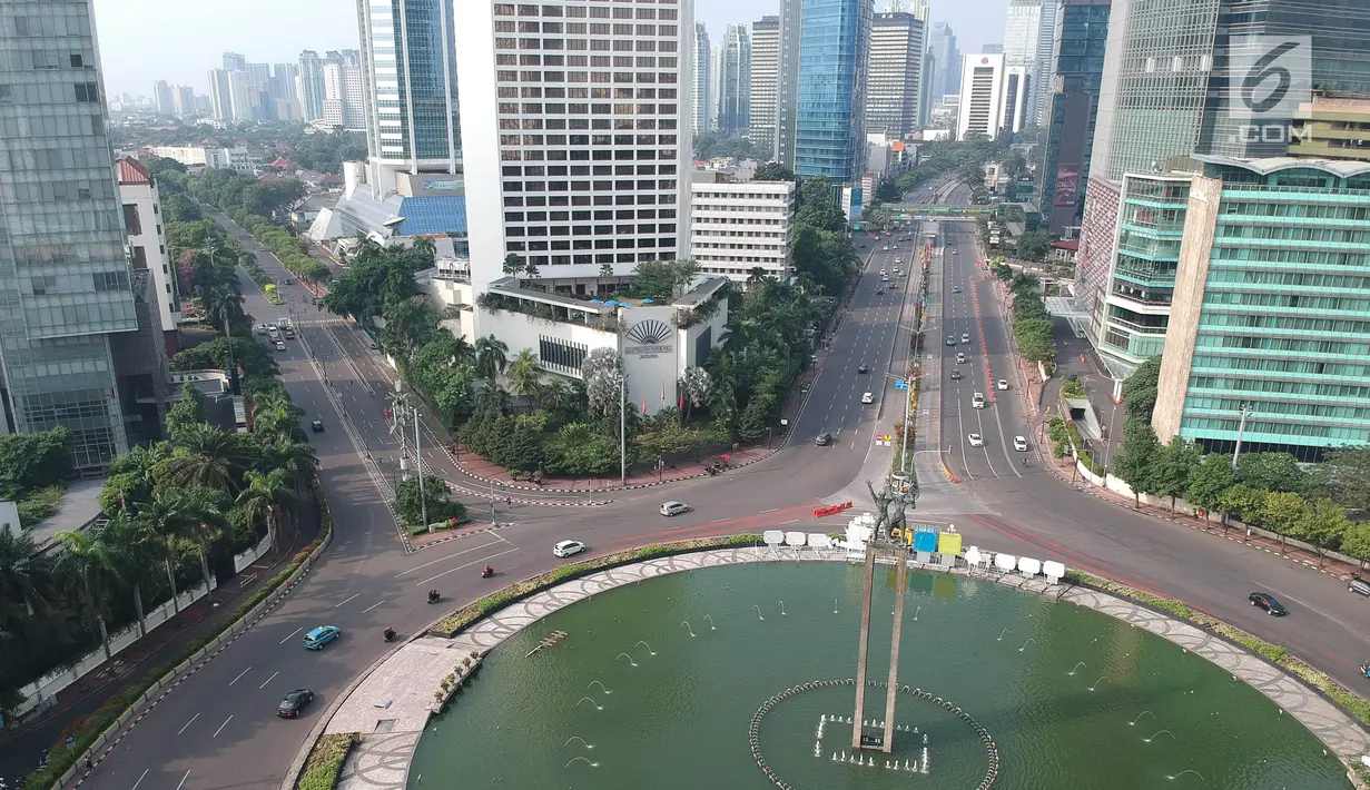 Foto Udara suasana jalan yang lengang di Jalan Thamrin, Jakarta, Jumat (15/6). Pada Hari Raya Lebaran hari pertama, sejumlah ruas jalan di Jakarta tampak sepi dan lengang, berbeda dengan kondisi normal yang padat dan macet. (Liputan6.com/Arya Manggala)