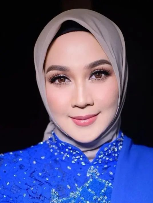 Dina Lorenza tak kalah memesona saat dipulas MUA @bennusorumba. Gaya riasannya berfokus pada riasan mata yang tajam dengan menggunakan eyeshadow coklat, bulu mata palsu yang bervolume dan lentik, serta alis yang dibentuk rapi.