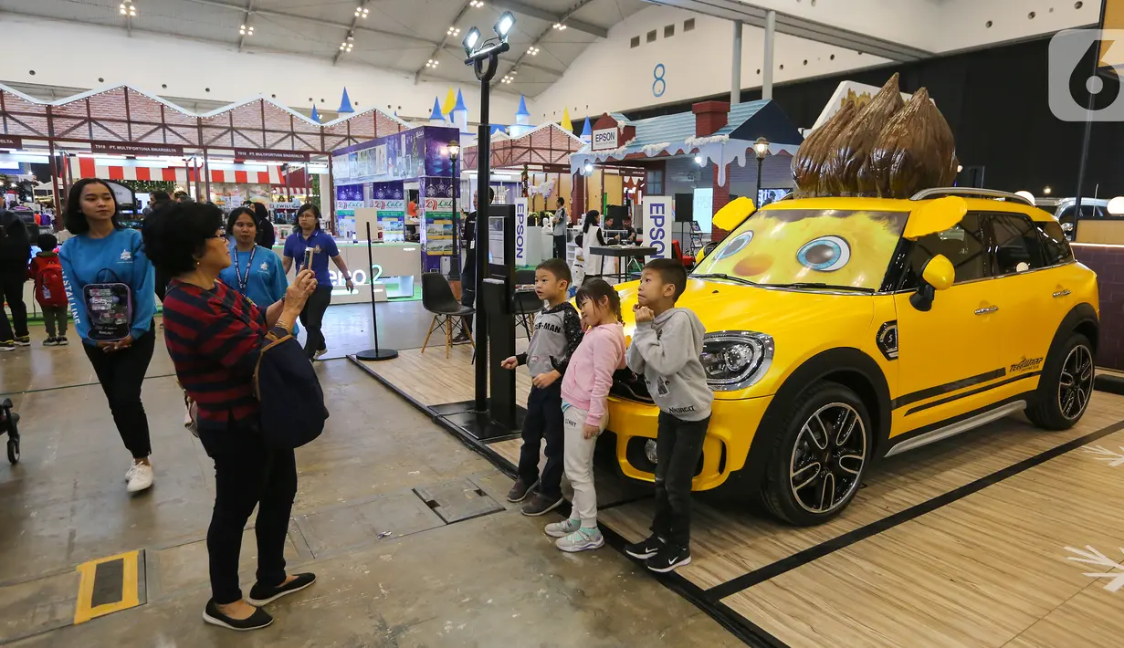 Anak-anak berfoto di depan mobil Mini Cooper pada gelaran ICEFEST 2019 di BSD Tangerang, Kamis (19/12/2019). ICEFEST 2019 dengan tiket masuk yang dibandrol Rp 50.000.- memberikan suguhan edukasi yang dikemas dengan hiburan kepada anak-anak. (Liputan6.com/Fery Pradolo)