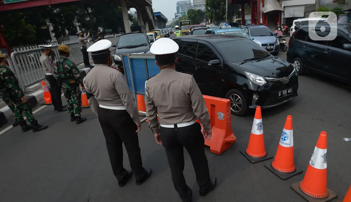 Petugas melakukan penjagaan di kawasan yang ditutup saat penyekatan di ruas jalan Mampang Prapatan, Jakarta, Kamis (15/7/2021). Mampang menjadi salah satu jalan yang masuk dalam penyekatan baru pada Pemberlakuan Pembatasan Kegiatan Masyarakat (PPKM) darurat di Ibu Kota. (merdeka.com/Imam Buhori)