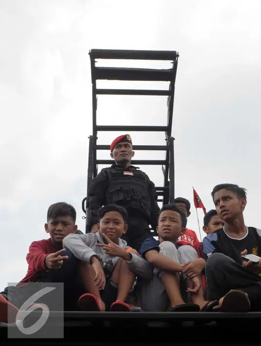 Sejumlah anak menaiki kendaraan tempur saat HUT Kopassus ke-64, Jakarta, (16/4). HUT Kopassus dihadiri Menkopolhukam luhut Binsar Pandjaitan dan Panglima TNI Gatot N. (Liputan6.com/Helmi Afandi)