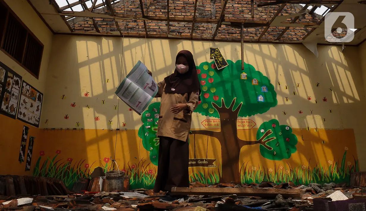 Murid Sekolah Dasar Negeri (SDN) Setiamekar 03 Tambun Selatan melihat ruangan kelas yang atapnya ambruk, Kabupaten Bekasi, Jawa Barat, Selasa (12/12/2023). (merdeka.com/Imam Buhori)