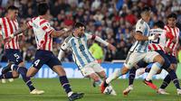 Aksi pemain Timnas Argentina, Lionel Messi (tengah), yang berusaha mengontrol bola saat pertandingan Kualifikasi Piala Dunia 2026 zona CONMEBOL melawan Paraguay di Stadion Mas Monumental, Jumat (13/10/2023) pagi WIB. Lionel Messi baru bermain pada menit ke-53 menggantikan Julian Alvarez. (AFP/Juan Mabromata)