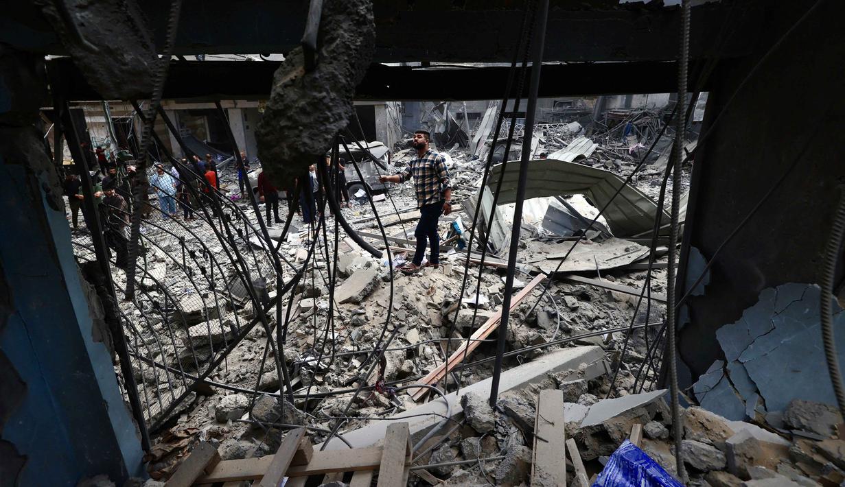Warga Palestina yang mengungsi memeriksa kerusakan setelah sebuah rumah menjadi sasaran serangan Israel di kamp pengungsi Maghazi, Jalur Gaza Tengah pada Kamis 21 Mei 2026. (Eyad Baba/AFP)