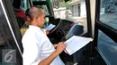 Petugas operator bus Transjakara memeriksa kilometer dan kondisi Bus Transjakarta di Koridor 6 Ragunan, Jakarta, Selasa, (30/6/2015). Bus yang melayani koridor tersebut terlihat banyak yang sudah tak layak jalan. (Liputan6.com/Yoppy Renato)