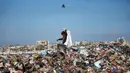 Timbunan sampah memicu ledakan populasi tikus dan serangga, yang meningkatkan risiko penyakit seperti leptospirosis dan insiden gigitan tikus pada anak-anak. Tampak dalam foto, seorang anak memilah sampah di kamp pengungsi Palestina, Nuseirat, Jalur Gaza Tengah pada Kamis 7 Mei 2026. (Eyad Baba/AFP)