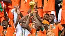 Penyerang Pantai Gading, Max-Alain Gradel (tengah) mengangkat trofi Piala Afrika di podium setelah memenangkan pertandingan sepak bola final Piala Afrika (CAN) melawan Nigeria di Stadion Olimpiade Alassane Ouattara, Ebimpe, Abidjan pada 11 Februari 2024. (Sia KAMBOU/AFP)