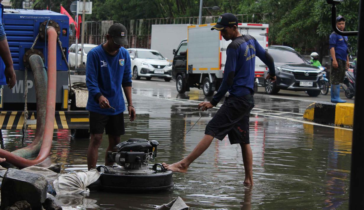 Air berangsur surut sekitar satu jam setelah tindakan penyedotan dilakukan secara intensif. Tampak dalam foto, petugas Dinas Sumber Daya Air (SDA) DKI Jakarta menyalakan pompa air apung sebagai upaya penanggulangan genangan banjir yang belum surut di Jalan Gunung Sahari Raya atau tepat di depan Mangga Dua Square, Jakarta, Selasa (13/1/2026). (merdeka.com/magang/Rendi Saputra)