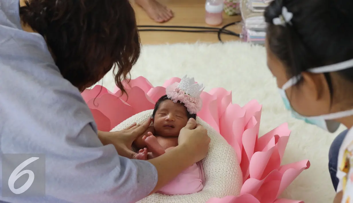 Akifa Dhinara Parasady sedang diarahkan untuk pemotretan di rumah kediamannya di Pondok Pinang, Jakarta, Kamis (20/10). Nindy melakukan sesi photoshoot baby born yang memang sedang ramai menjadi tren (Liputan6.com/Herman Zakharia) 