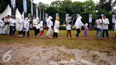 Warga melewati titian kayu saat menghadiri Doa Bersama Untuk Satukan Umat Jakarta di Lapangan Blok S, Kamis (9/2). Tabliq akbar tersebut dihadiri pasangan cagub DKI Jakarta Agus Harimurti Yudhoyono dan Sylviana Murni. (Liputan6.com/Helmi Fithriansyah)