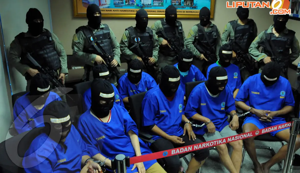 Sepuluh tersangka dihadirkan ke ruang pertemuan VIP BNN dengan memakai penutup muka dan baju tahanan BNN berwarna biru (Liputan6.com/Faisal R Syam)