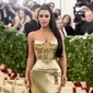 Aktris Kim Kardashian berpose saat menghadiri Met Gala 2018 di Metropolitan Museum of Art, New York (7/5). Kim Kardashian tampil seksi mengenakan gaun emas super ketat. (AP Photo/Evan Agostini)