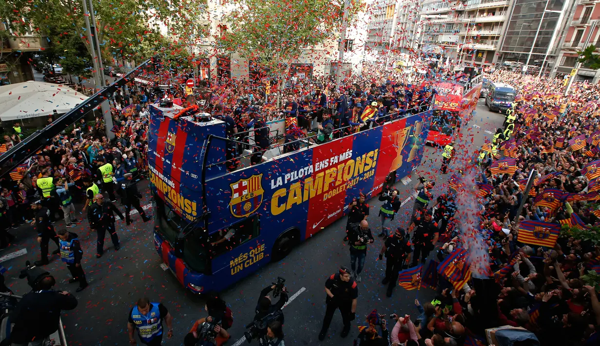 Para pemain Barcelona berada di atas bus saat melakukan parade di Barcelona (30/4). Parade ini untuk merayakan juara La Liga Spanyol yang berhasil diraih oleh tim sepak bola Barcelona. (AP/Manu Fernandez)