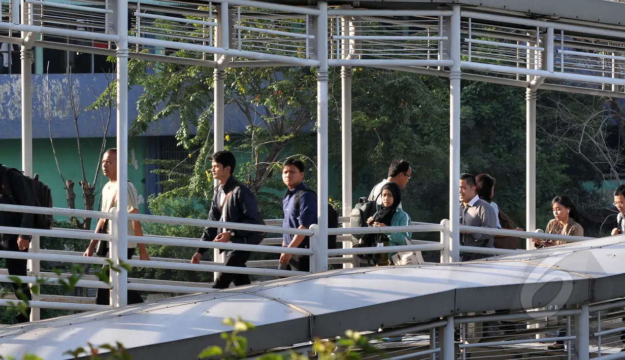 Para pekerja berjalan di jembatan khusus busway, Jakarta, Rabu, (22/4/2015). Adanya pengalihan arus untuk KAA membuat mereka terpaksa jalan kaki. (Liputan6.com/Johan Tallo)