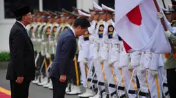 Penandatanganan tersebut merupakan bagian dari rangkaian Defence Minister Meeting 2026. Tampak dalam foto, Menteri Pertahanan Jepang Shinjiro Koizumi (tengah) membungkuk memberi hormat kepada bendera nasional Indonesia dan Jepang saat memeriksa barisan kehormatan bersama Menteri Pertahanan Republik Indonesia, Sjafrie Sjamsoeddin (kiri), selama upacara penyambutan di Jakarta, Senin 4 Mei 2026. (AP Photo/Achmad Ibrahim)