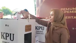 Salah seorang warga memperagakan proses pemungutan suara yang dilaksanakan KPU RI di salah satu TPS wilayah Kukusan, Depok, Jawa Barat. (Liputan.com/Dicky Agung Prihanto)