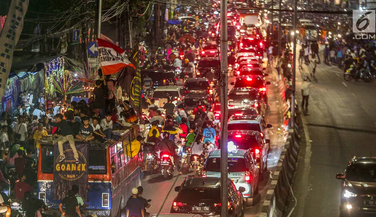 Kemacetan terjadi saat warga konvoi menggunakan bus untuk merayakan malam takbiran menyambut Hari Raya Idul Fitri 2019 di kawasan Tanah Abang, Jakarta, Selasa (4/6/2019). Pemerintah menetapkan Hari Raya Idul Fitri 1440 Hijriah jatuh pada hari Rabu 5 Juni 2019. (Liputan6.com/Faizal Fanani)