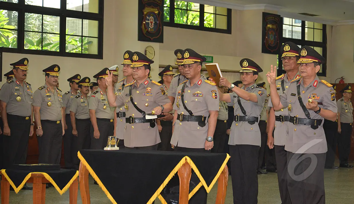 Irjen Pol Ronny Frangky Sompie (kiri) dan Irjen Pol Ronny Frangky Sompie (tengah) mengambil sumpah jabatan saat upacara pelantikan dan sertijab Kadiv Humas Mabes Polri dan tiga Kapolda di Mabes Polri, Selasa (17/3/2015). (Liputan6.com/Johan Tallo)