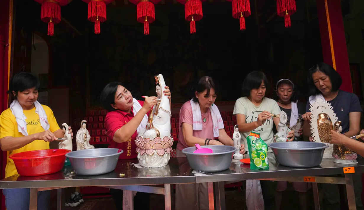 Para wanita membersihkan patung dewa Tionghoa dalam persiapan perayaan Tahun Baru Imlek di Vihara Dhanagun, Bogor, Jawa Barat, Indonesia, 16 Januari 2023. Warga keturunan Tionghoa di Indonesia bersiap untuk merayakan Tahun Baru Imlek pada 22 Januari 2023. (AP Photo/Tatan Syuflana)