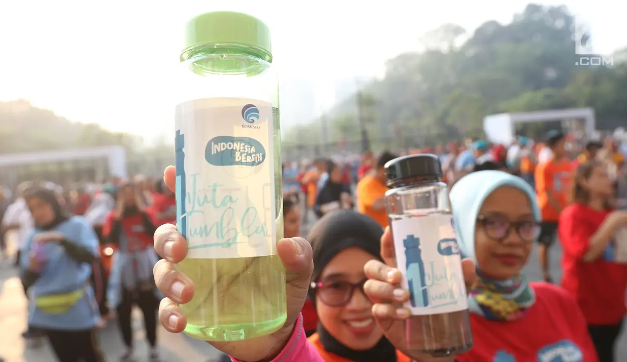 Warga menunjukkan tumbler saat mengikuti gerakan 1 juta  tumbler di GBK, Senayan, Jakarta, Minggu (28/7/2019). Sekitar 1.500 orang antusias mengikuti senam bersama dalam acara gerakan 1 juta  tumbler tersebut. (Liputan6.com/Angga Yuniar)