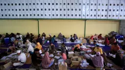 Puluhan orang terlibat dalam proses pelipatan surat suara Pemilu 2024 di Gudang KPU Yogyakarta yang ada di Bantul. Dalam pelipatan surat suara tersebut KPU Yogyakarta turut melibatkan para difabel. (DEVI RAHMAN/AFP)