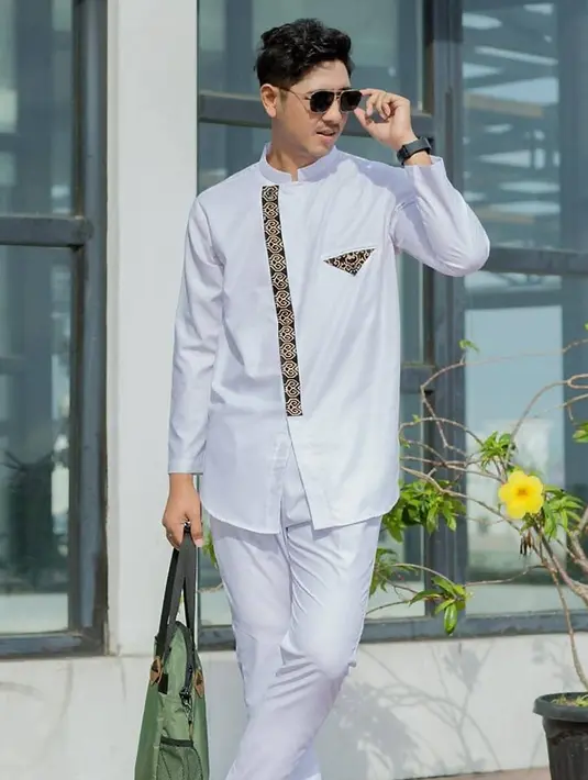 Busana muslim yang seperti baju koko ini menjadi sangat populer di antara para penggemar. Mengkombinasikan dengan kaca mata, gayanya saat pakai busana muslim ini pun cocok sebagai fashion saat jalan-jalan. (Liputan6.com/IG/arya.saloka)