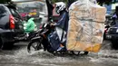 Sejumlah kendaraan melintasi genangan air di Jalan Iskandar, Jakarta, Kamis (22/1/2015). (Liputan6.com/Miftahul Hayat)