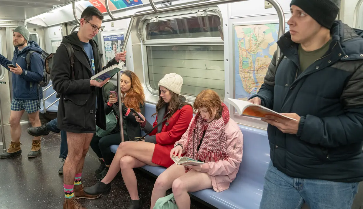 Penumpang berada di dalam kereta F selama No Pants Subway Ride ke-18 di New York City (13/1). No Pants Subway Ride ajang tahunan yang sudah menyebar ke berbagai kota besar di dunia. (AFP Photo/David 'Dee' Delgado)