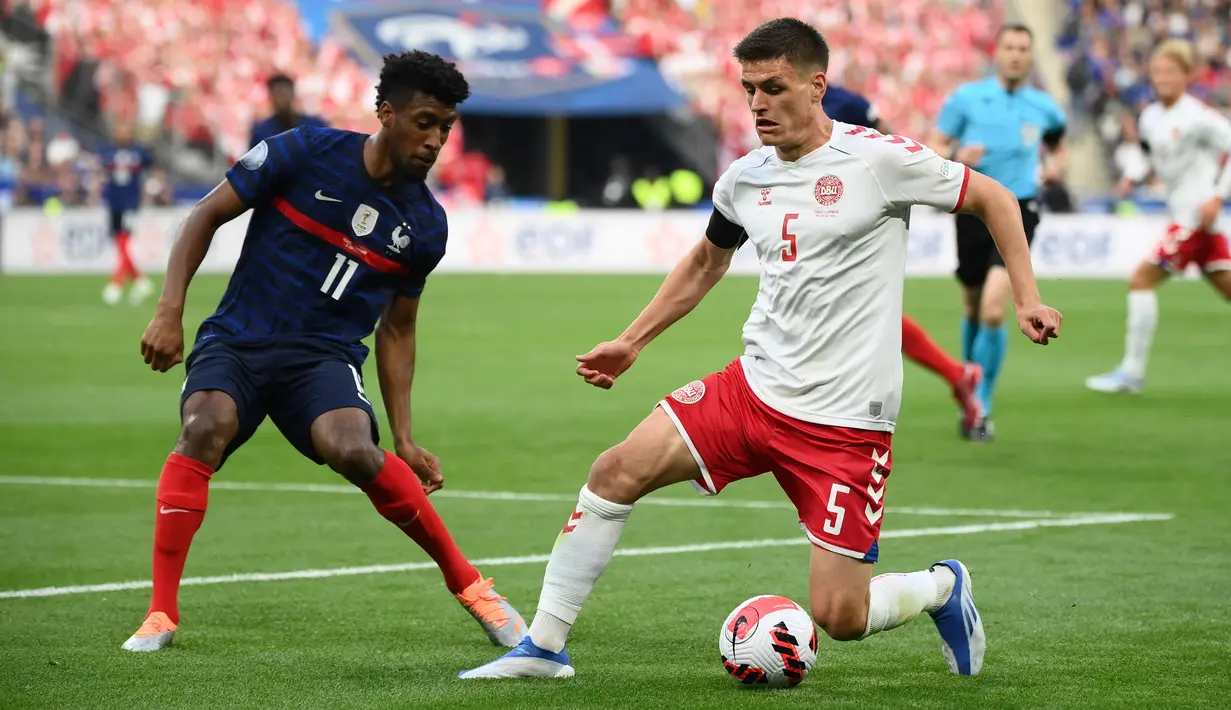 Bek timnas Denmark Joakim Maehle (kanan) berebut bola dengan penyerang Prancis Kingsley Coman pada laga perdana Grup A UEFA Nations League di Stade de France, Paris, Prancis, Sabtu(4/6/2022) dini hari WIB. Prancis harus rela menelan kekalahan 1-2 dari tamunya Denmark. (Franck FIFE / AFP)