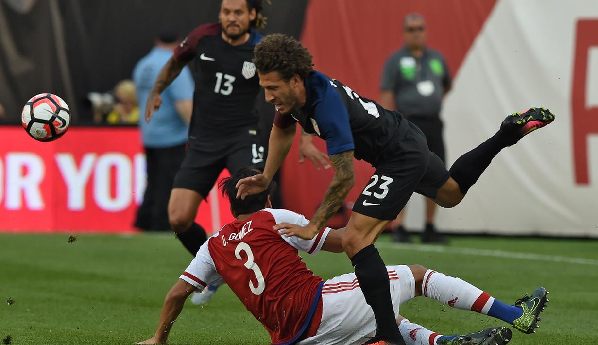 Pemain AS, Fabian Johnson, duel dengan pemain Paraguay, Gustavo Raul Gomez, dalam laga Grup A Copa America Centenario 2016 di Stadion Lincoln Financial Field, Philadelphia, AS, Minggu (12/6/2016) WIB. (AFP/Don Emmert)