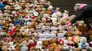 Seorang siswa meletakkan satu dari 740 boneka beruang atau Teddy Bears di tangga Concert Hall, Berlin, Kamis (15/3). Boneka beruang ini melambangkan 740 ribu anak pengungsi Suriah yang tidak dapat bersekolah. (AFP PHOTO/Odd ANDERSEN)
