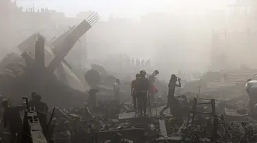 Warga Palestina mencari korban di atas puing-puing bangunan yang hancur usai pengeboman Israel, di Khan Younis di Jalur Gaza Selatan pada 26 Oktober 2023. (Mahmud HAMS/AFP)