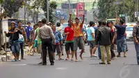 Puluhan pedagang yang tidak diterima dagangannya dibersihkan melempari petugas dengan beling dan batu, Jakarta, (30/9/14). (Liputan6.com/Faizal Fanani)