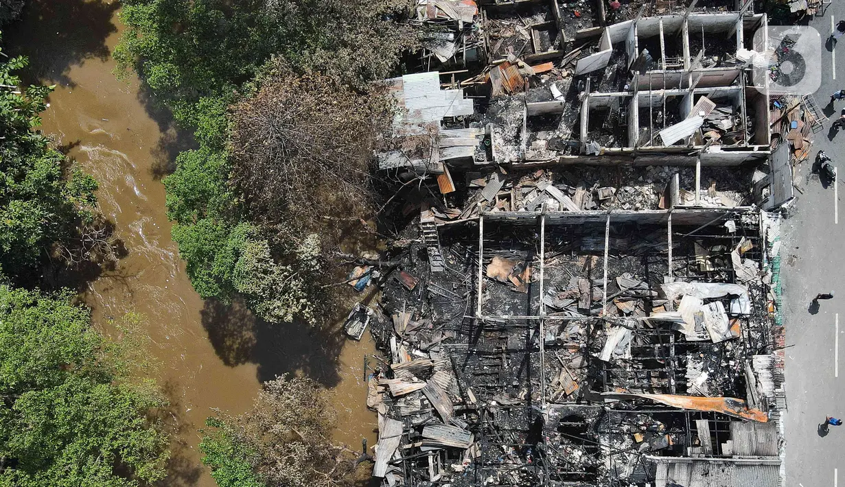 Foto udara lokasi kebakaran pemukiman di kawasan Manggarai, Jakarta, Minggu (18/12/2022). Kebakaran tersebut menghanguskan sekitar 50 rumah semi permanen yang ada di bantaran sungai Ciliwung. (Liputan6.com/Herman Zakharia)