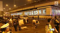 Petugas memasang garis pembatas di lokasi terjadinya ledakan di sekitar Terminal Kampung Melayu, Jakarta, Rabu (24/5). Polisi belum bisa memastikan apakah tiga korban jiwa itu merupakan anggota polisi atau warga sipil. (Liputan6.com/Angga Yuniar)