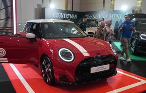 Orang-orang melihat kendaraan listrik MINI 1965 Victory Edition selama acara peluncurannya di Jakarta, Jumat 17 April 2026. MINI Indonesia secara resmi meluncurkan model edisi terbatas MINI 1965 Victory Edition. (AP Photo/Tatan Syuflana)