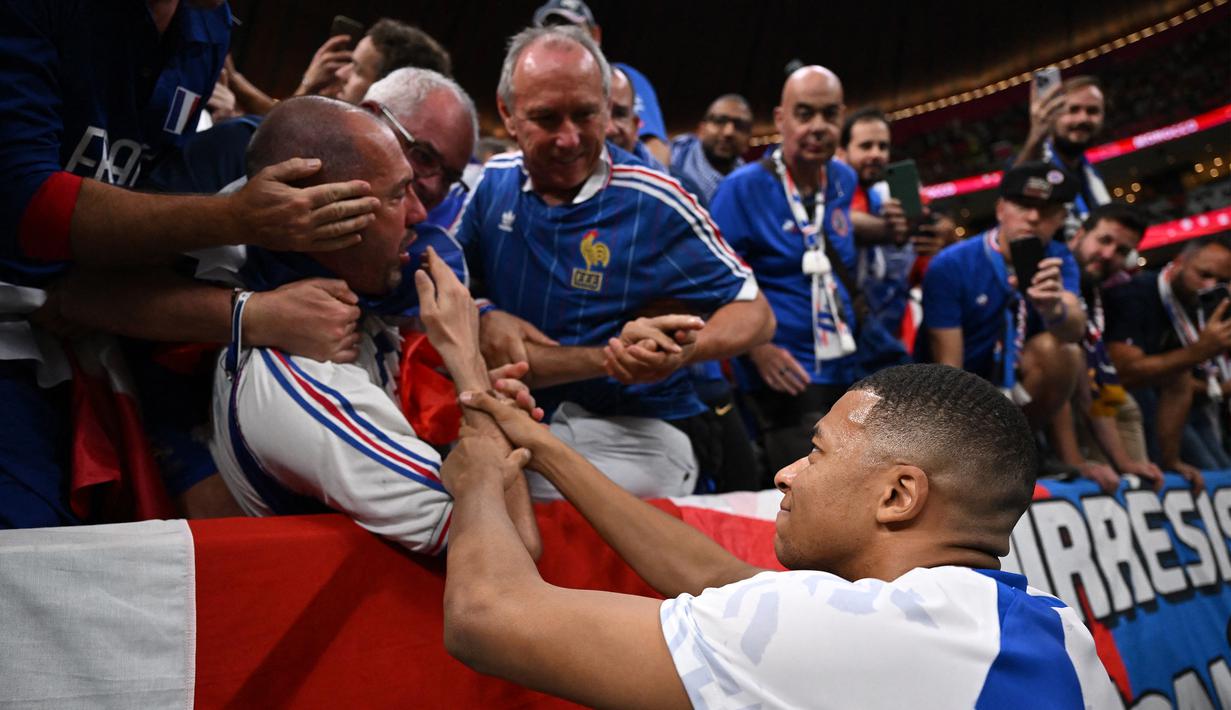 Mbappe kemudian memastikan korban baik-baik saja. Sang penggemar lantas terkejut setelah menyadari bahwa bintang Timnas Prancis itu turut memeriksanya. Mbappe pun kemudian berlari kembali ke lapangan. (AFP/Kirill Kudryavtsev)