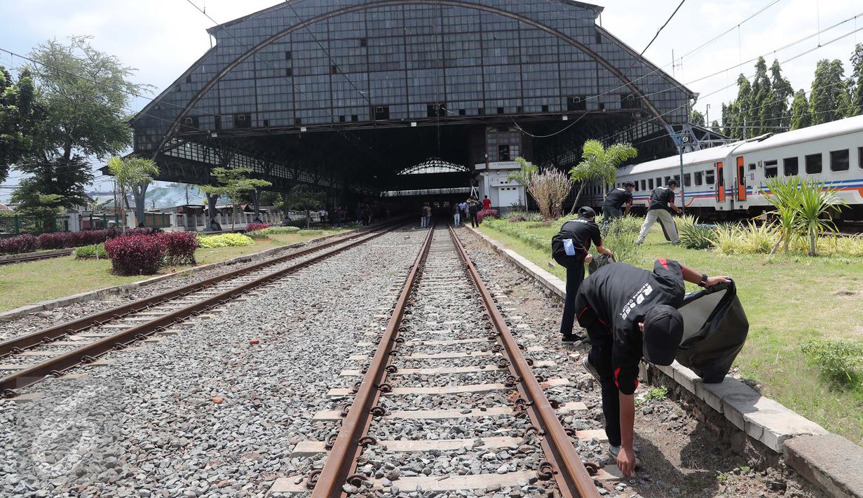Komunitas Pecinta Kereta Api RD One memungut sampah yang berada di sekitaran Stasiun Tanjung Priok, Jakarta Utara, Kamis (6/4). Acara HUT diakhiri dengan doa bersama dan ramah tamah antar anggota pecinta kereta api. (Liputan6.com/Gempur M. Surya)