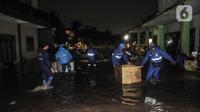 Petugas gabungan saat mengevakuasi reruntuhan pasca robohnya tembok bangunan akibat terjangan banjir di Madrasah Tsanawiyah (MTs) Negeri 19 di Jalan Pinang Kalijati, Pondok Labu, Cilandak, Jakarta Selatan, Kamis (6/10/2022). Peristiwa robohnya tembok sekolah bersamaan dengan hujan deras pada sore tadi tersebut diakibatkan oleh terjangan banjir yang menyebabkan tiga siswa tewas dan dua lainnya luka-luka. (merdeka.com/Iqbal S. Nugroho)