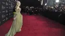 Elle Fanning tertawa di karpet merah pemutaran perdana film Disney "Maleficent: Mistress of Evil" di Teater El Capitan di Hollywood (30/9/2019). Elle Fanning tampil bergaun hijau dengan sarung tangan tipis dann tetesan darah merah berhiaskan permata di tangan kanannya. (AP Photo/Richard Shotwell)