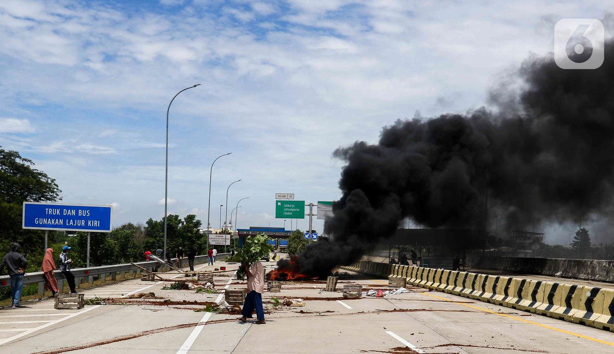 Sejumlah warga melakukan aksi menutup akses jalan menuju Gerbang Tol (GT) Jatikarya 1& 2, di Jalan tol Cimanggis-Cibitung, Bekasi, Jawa Barat, Rabu (8/2/2023). Dalam aksinya mereka menuntut Pengadilan Negeri Kota Bekasi segera menyelesaikan pembayaran atas penggunaan tanah untuk tol seluas 4,2 hektar. (Liputan6.com/Herman Zakharia)