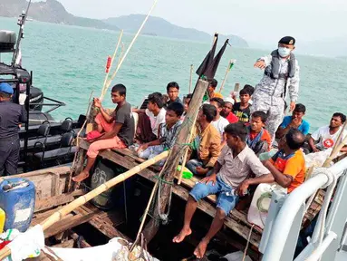Pasukan AL Malaysia menahan sebuah perahu yang membawa pengungsi Rohingya di Langkawi, Malaysia, Selasa (3/4). Otoritas Malaysia meningkatkan patroli untuk mencegat kapal pengungsi Rohingya mencari perlindungan di negara itu. (Royal Malaysian Navy via AP)
