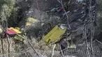 Perwira militer dan petugas pemadam kebakaran mencari puing-puing pesawat pemadam kebakaran Canadair CL-215, yang jatuh di dekat lokasi saat diterbangkan untuk memadamkan kebakaran hutan di Karystos, di pulau Aegean Yunani Evia, Selasa (25/7/2023). (STRINGER / AFP)