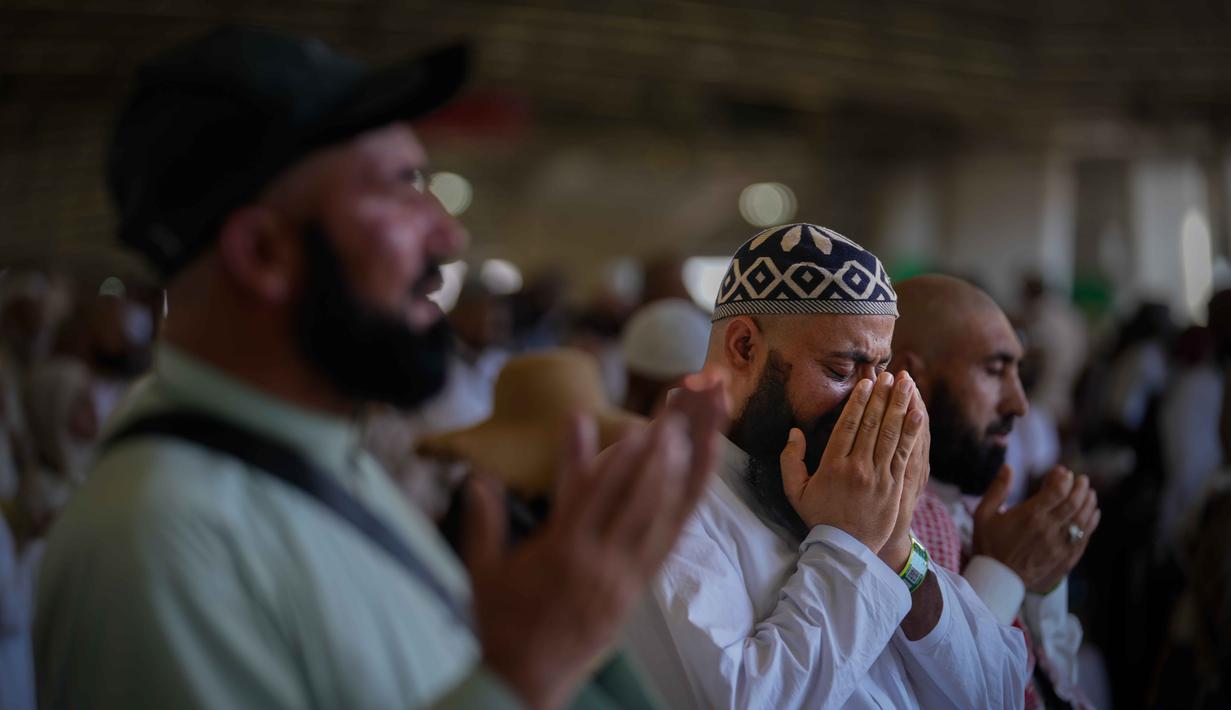 Seorang jemaah Muslim terisak-isak saat berdoa setelah melempar kerikil ke tiang-tiang sebagai simbol pelemparan batu ke setan pada hari kedua ritual, salah satu upacara terakhir ibadah haji tahunan, di Mina, Arab Saudi, Kamis 28 Mei 2026. (AP Photo/Altaf Qadri)