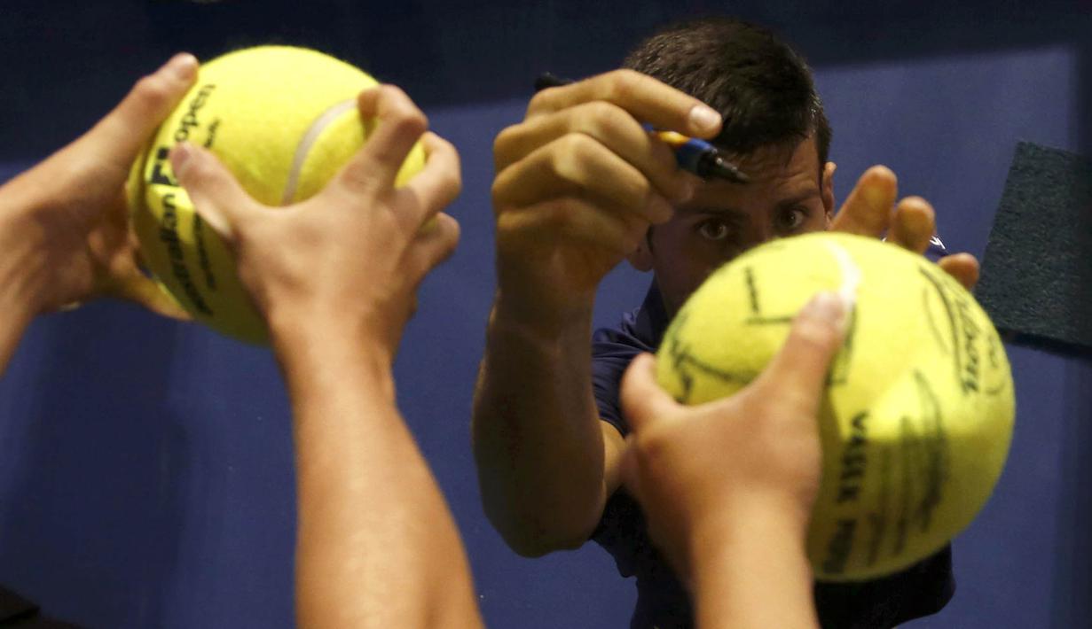Petenis putra Serbia, Novak Djokovic, memberikan tanda tangan kepada penggemarnya seusai bertanding melawan petenis Jepang, Kei Nishikori, di perempatfinal Australia Terbuka 2016 di Melbourne Park, Australia, (26/1/2016). ( Reuters/Brandon Malone)