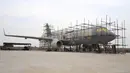 Orang-orang menyelesaikan pembuatan replika pesawat Airbus A320 skala penuh di Kaiyuan, timur laut China, 25 Oktober 2018. Replika pesawat Airbus A320 yang hampir selesai itu diparkir permanen di sepetak lahan yang dikelilingi ladang gandum. (STR/AFP)